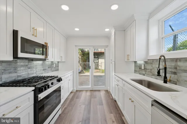 a kitchen with stainless steel appliances granite countertop a sink stove and microwave