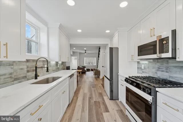 a kitchen with granite countertop a sink stainless steel appliances and cabinets