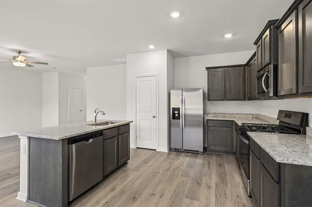 a kitchen with stainless steel appliances granite countertop a sink stove and refrigerator