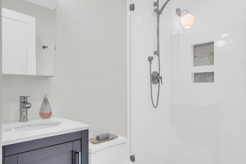 70 Middle Street Lexington, MA 02421 - Photo 28 of 37 a bathroom with a shower sink and mirror