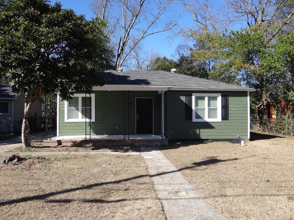 a front view of a house with a yard and trees