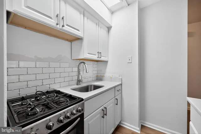 a kitchen with a stove and a white cabinet