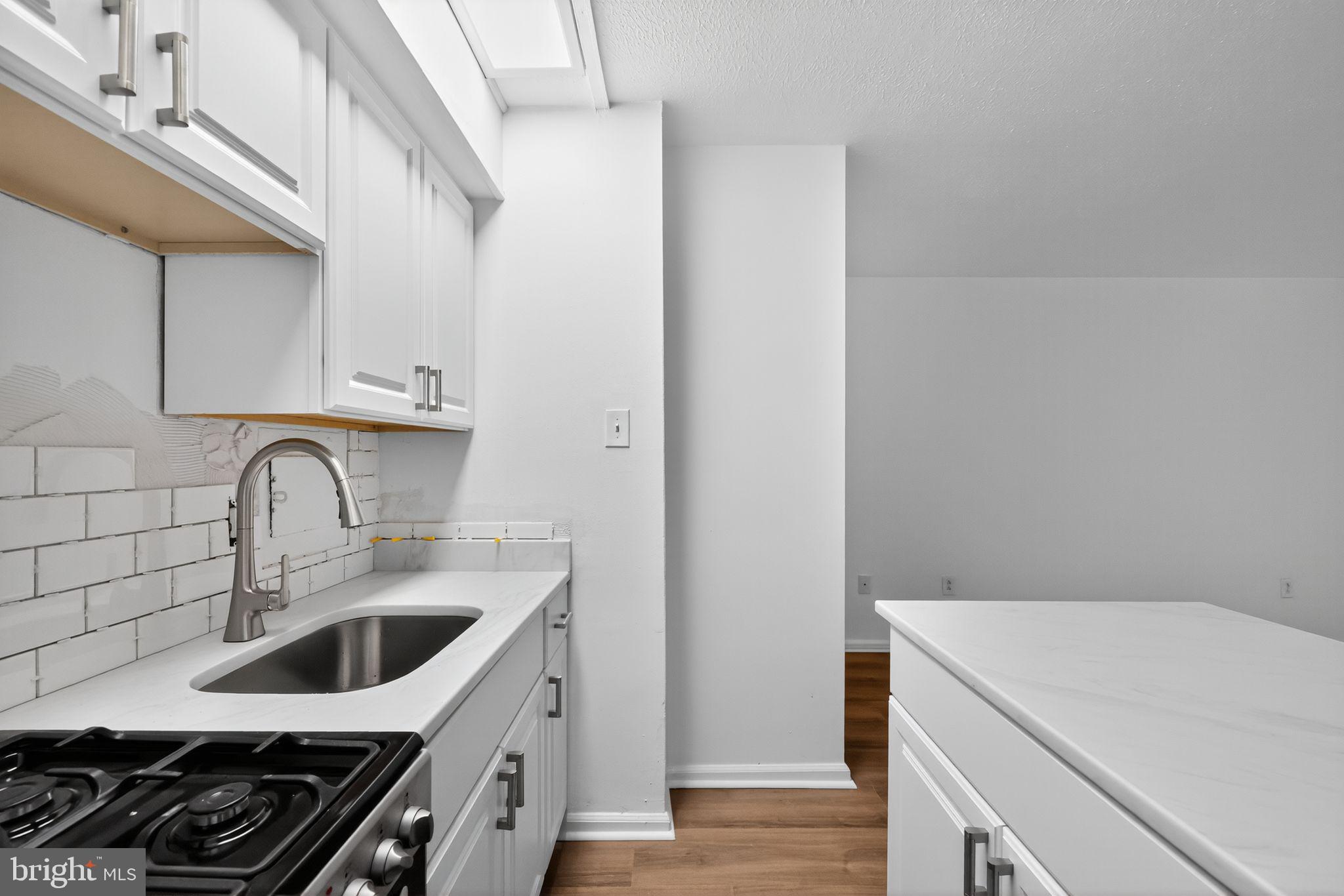 2101-17 Chestnut Street, Unit 1121 Philadelphia, PA 19103 - Photo 20 of 42 a kitchen with a sink stove top oven and cabinets