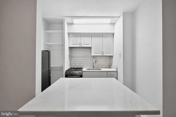 a kitchen with white cabinets and a stove