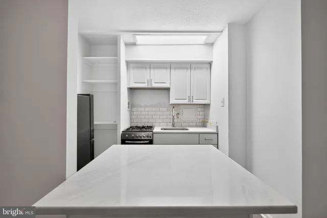 a kitchen with white cabinets and a stove