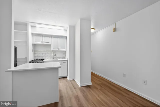a kitchen with kitchen island a sink and wooden floor