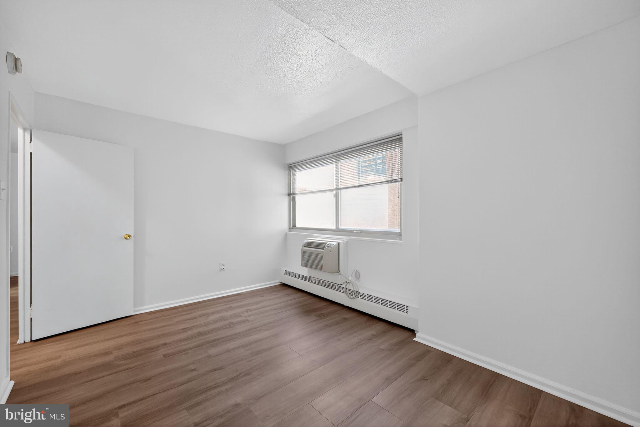 2101-17 Chestnut Street, Unit 1121 Philadelphia, PA 19103 - Photo 28 of 42 an empty room with wooden floor and windows