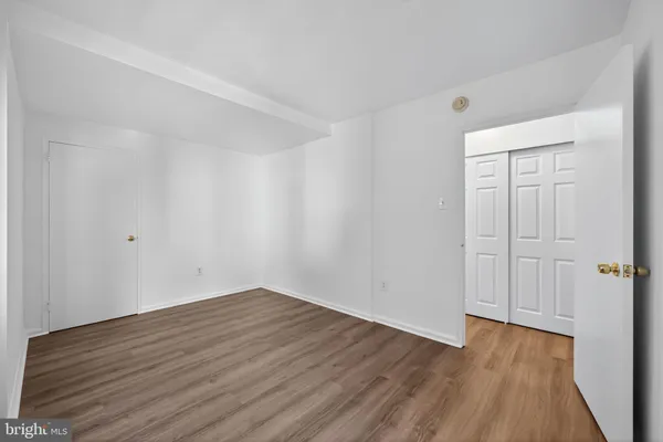 a view of a room with wooden floor and white doors