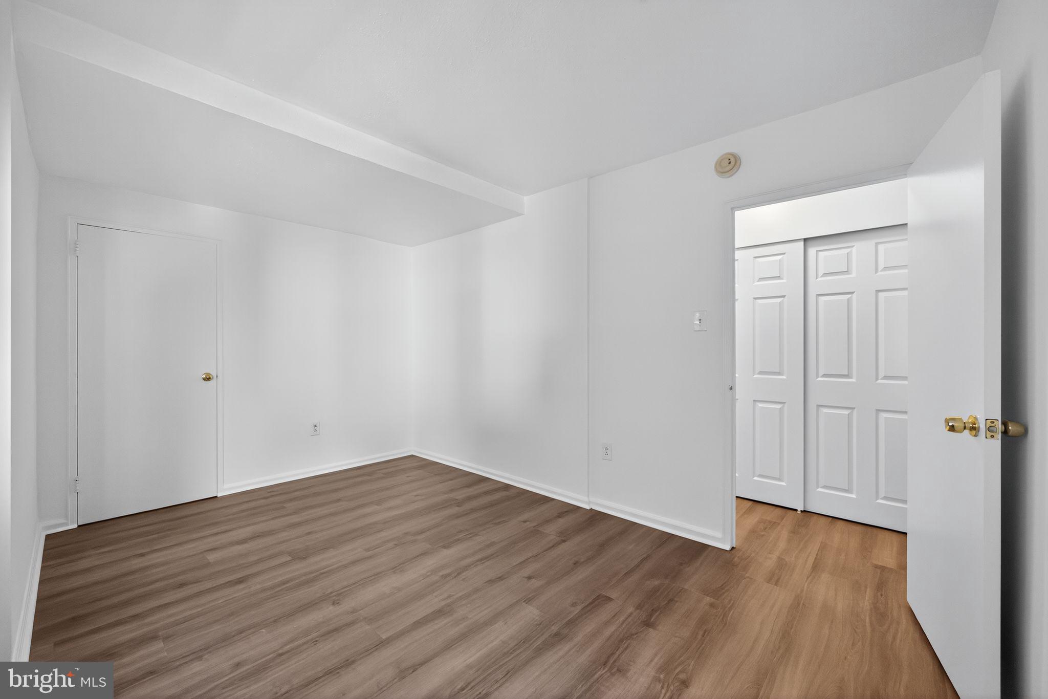 2101-17 Chestnut Street, Unit 1121 Philadelphia, PA 19103 - Photo 29 of 42 a view of a room with wooden floor and white doors