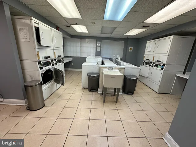 a utility room with dryer washer and a view of living room