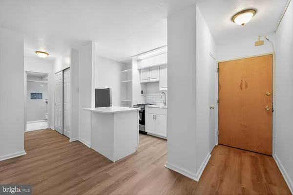 a view of kitchen with wooden floor and electronic appliances