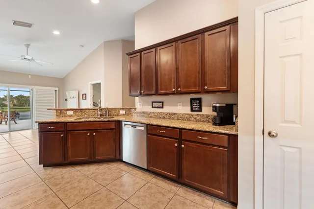 a large kitchen with granite countertop a sink dishwasher stove and cabinets