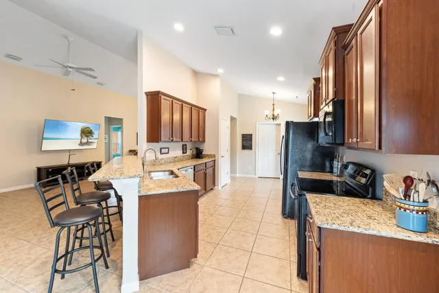 a kitchen with stainless steel appliances kitchen island granite countertop a refrigerator and a stove top oven