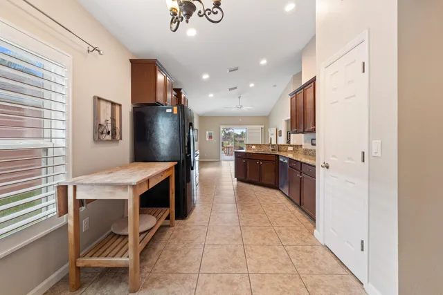 a kitchen with stainless steel appliances granite countertop a refrigerator a stove and a sink