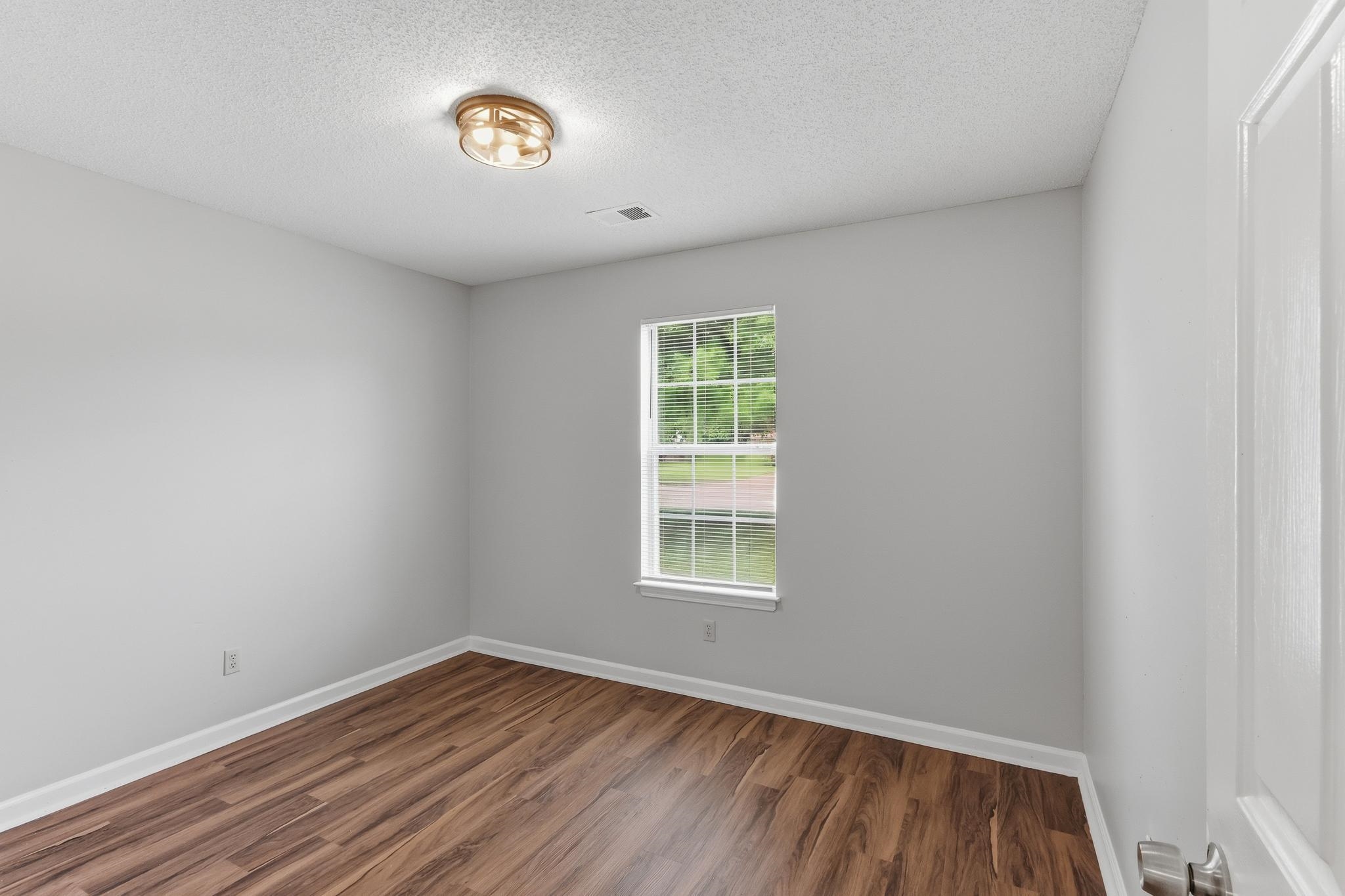 4101 Long Creek Road Memphis, TN 38125 - Photo 22 of 36 Room featuring wood-finish flooring, light gray walls, and white trim