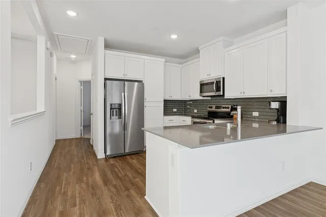 a kitchen with stainless steel appliances granite countertop a refrigerator a stove top oven a sink and dishwasher