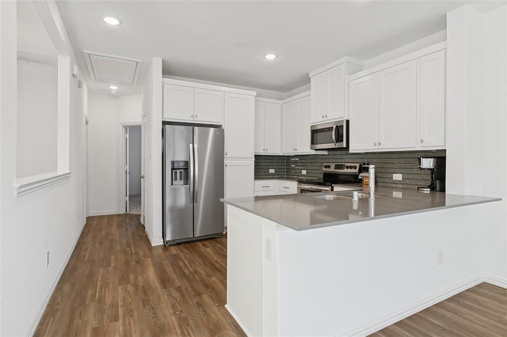 4703 Kindred Street Haltom City, TX 76117 - Photo 12 of 23 a kitchen with stainless steel appliances granite countertop a refrigerator a stove top oven a sink and dishwasher