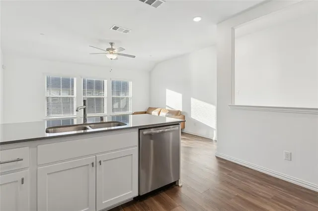 a kitchen with a sink cabinets and wooden floor