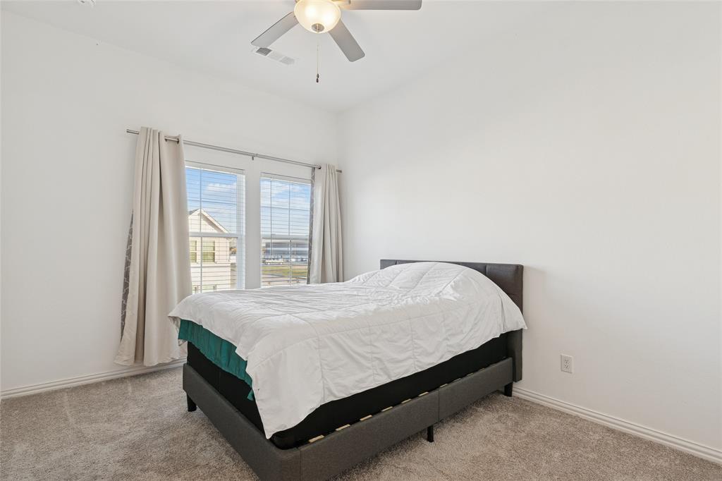 4703 Kindred Street Haltom City, TX 76117 - Photo 18 of 23 a bed sitting in a bedroom next to a window