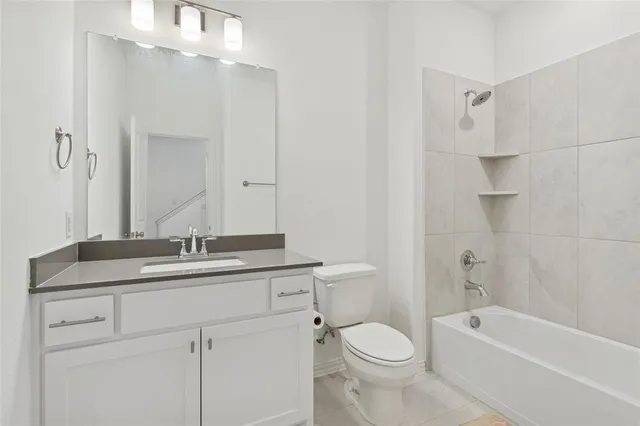 a bathroom with a granite countertop sink a toilet a mirror and shower