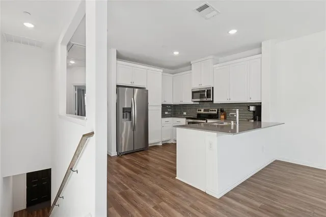 a kitchen with stainless steel appliances granite countertop a refrigerator and a stove top oven