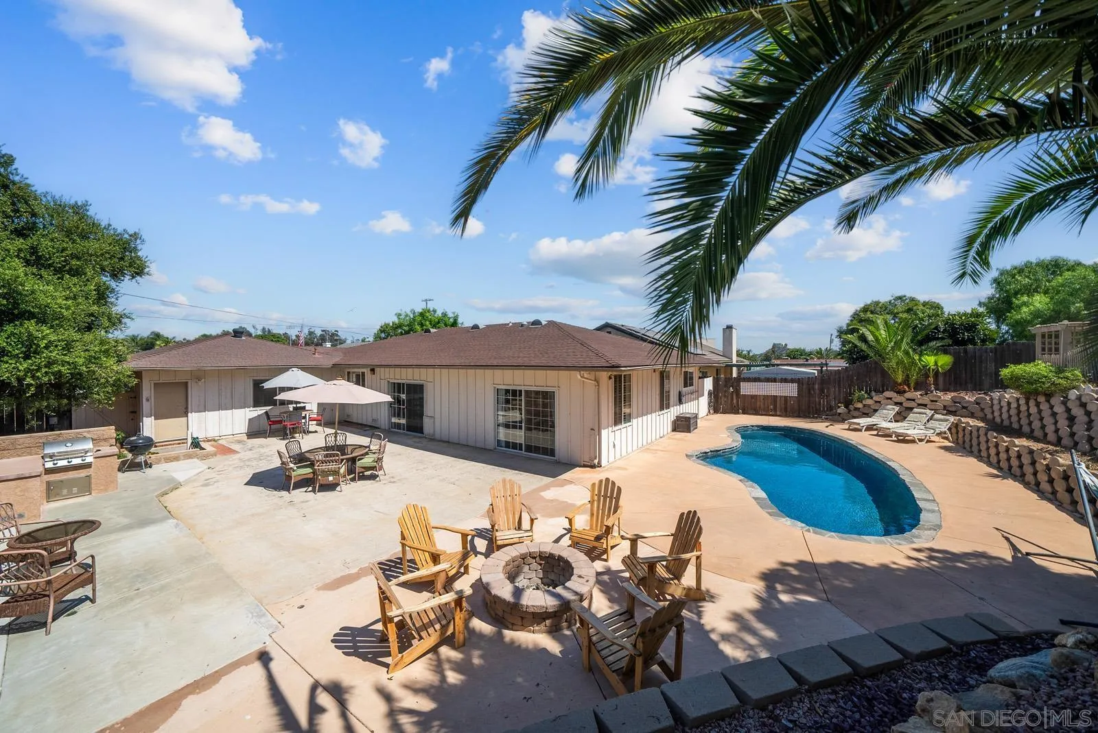 a view of a house with swimming pool and sitting area