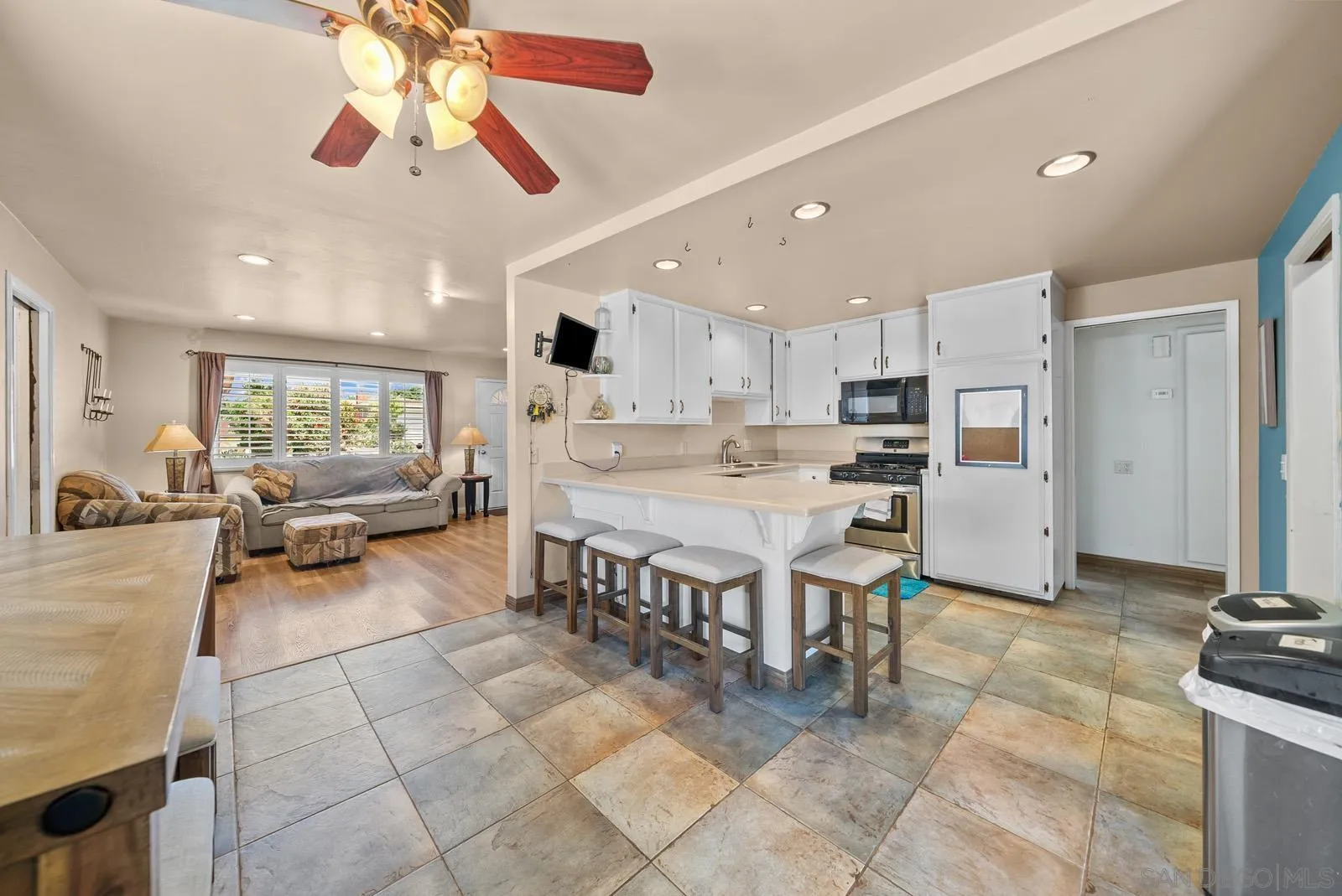 2327 Morro Road Fallbrook, CA 92028 - Photo 7 of 75 a kitchen with stainless steel appliances kitchen island granite countertop a refrigerator a stove a sink dishwasher and white cabinets with wooden floor