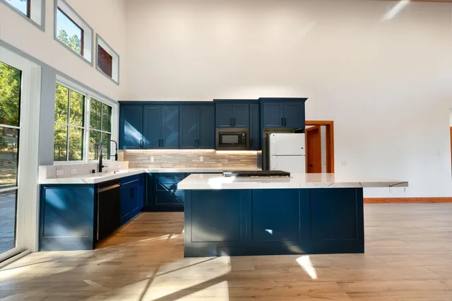 a view of house with yard outdoor seating and covered with trees
