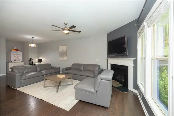 a living room with furniture a fireplace and a large window