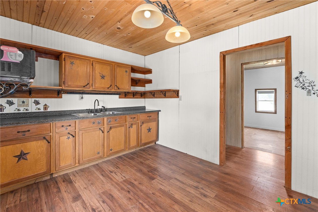 586 Private Road 3448 Kempner, TX 76539 - Photo 11 of 40 a kitchen with granite countertop white cabinets and wooden floor
