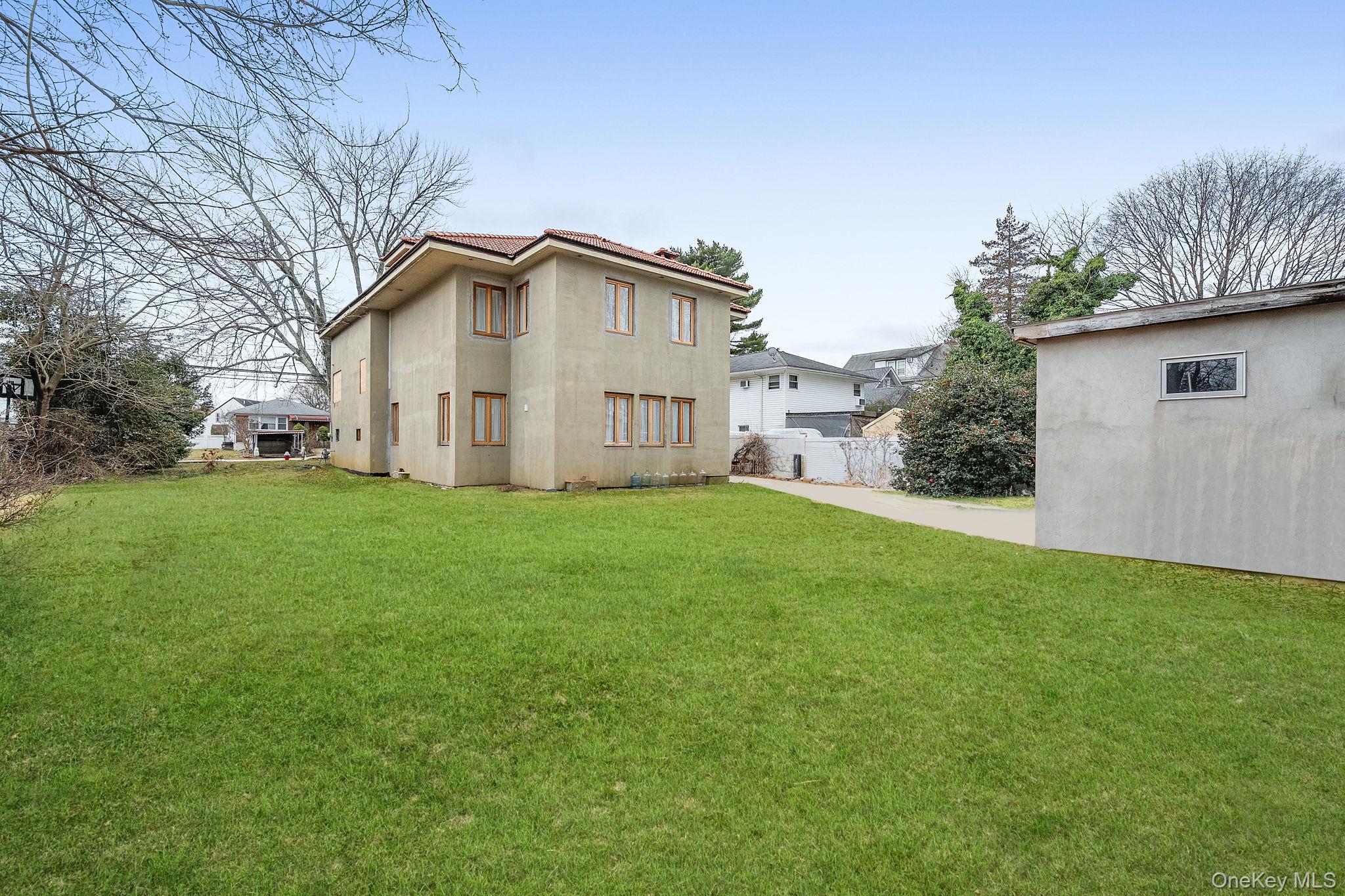 181 Walnut Street Lynbrook, NY 11563 - Photo 31 of 46 Rear view of house featuring stucco siding