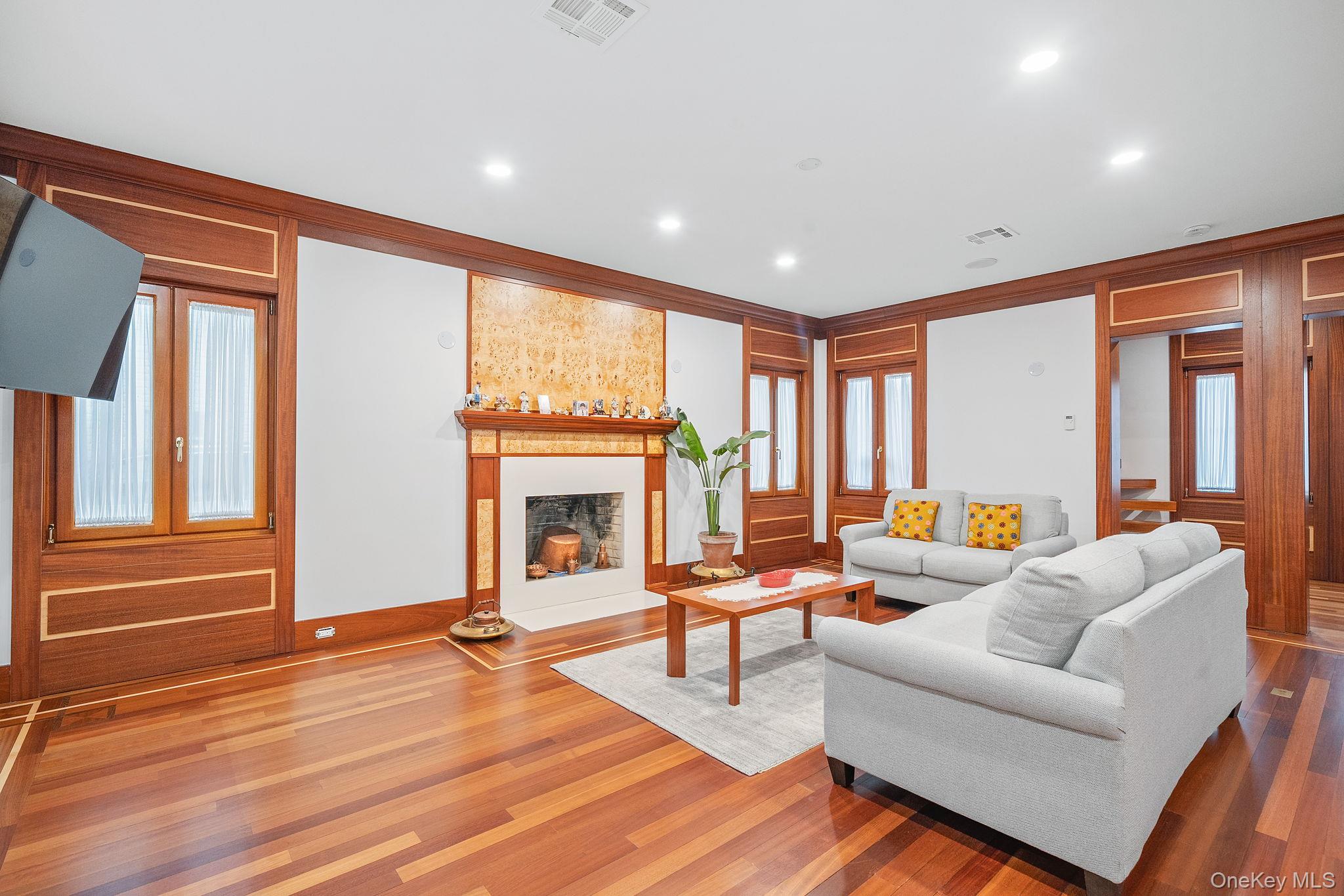 181 Walnut Street Lynbrook, NY 11563 - Photo 5 of 46 Living area featuring a fireplace with raised hearth, recessed lighting, and wood finished floors