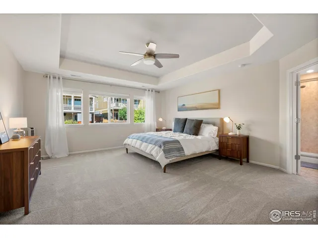 a bedroom with a bed next to a window with a chandelier