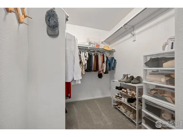 a view of walk in closet with clothes and shoes
