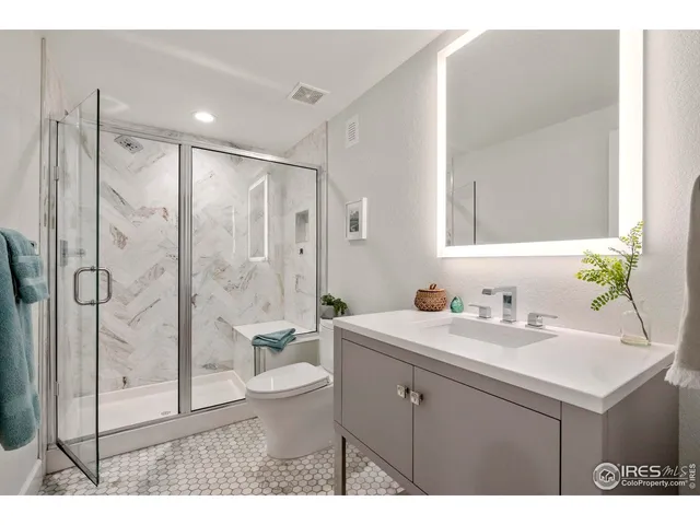 a bathroom with a sink toilet a mirror and shower