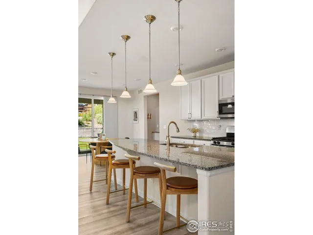 a kitchen with stainless steel appliances kitchen island granite countertop a sink a stove and a microwave
