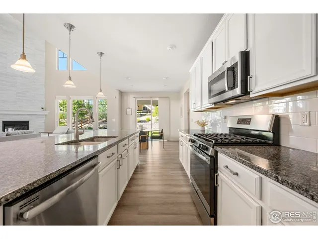 a large kitchen with stainless steel appliances granite countertop a stove a sink and a microwave