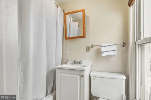 a bathroom with a toilet sink vanity and mirror