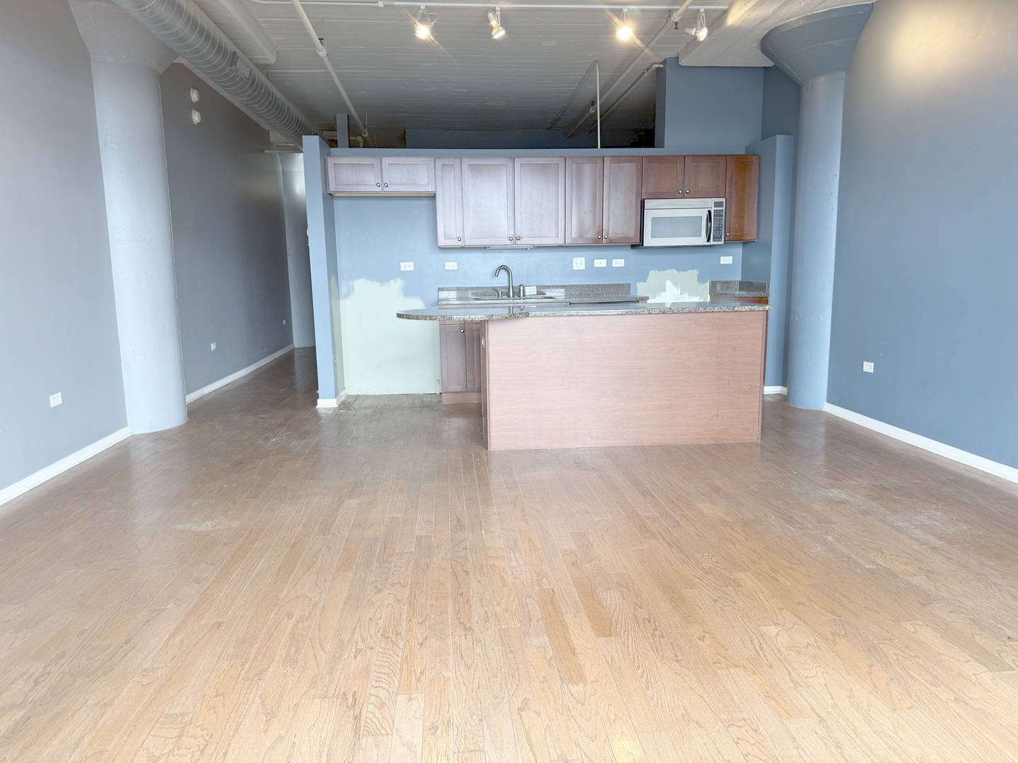 1525 South Sangamon Street, Unit 414 Chicago, IL 60608 - Photo 11 of 22 a view of kitchen with kitchen island a sink wooden floor and stainless steel appliances