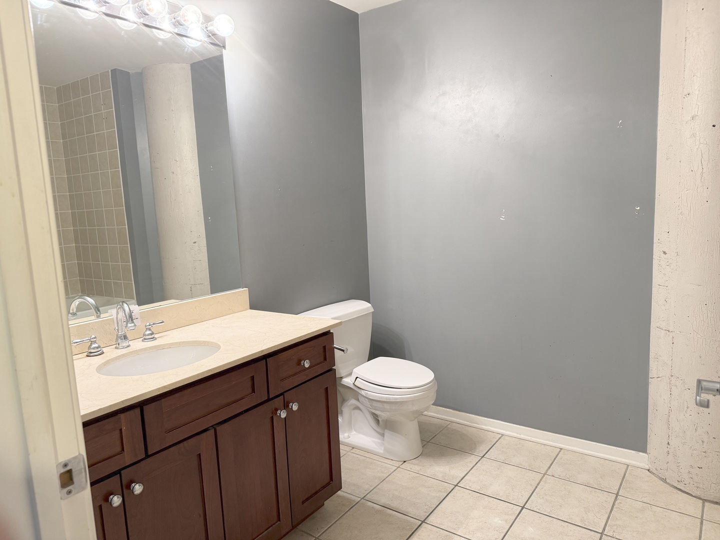 1525 South Sangamon Street, Unit 414 Chicago, IL 60608 - Photo 5 of 22 a bathroom with a sink a toilet a mirror and vanity