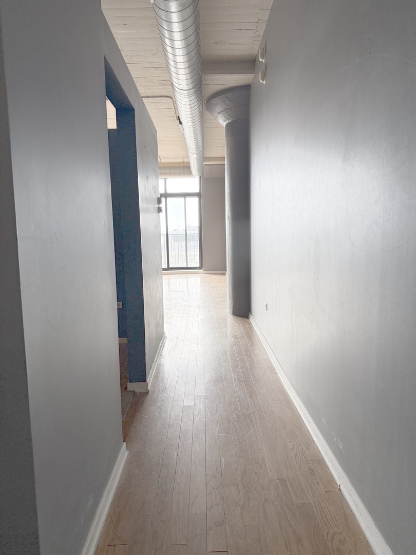 1525 South Sangamon Street, Unit 414 Chicago, IL 60608 - Photo 8 of 22 a view of a hallway with wooden floor