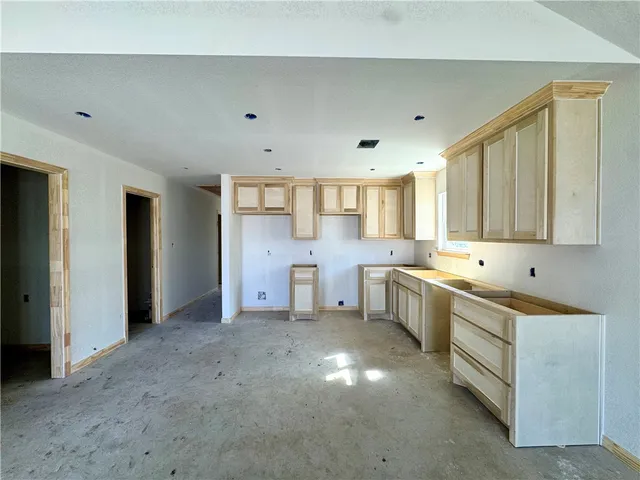 a large white kitchen with a sink and cabinets