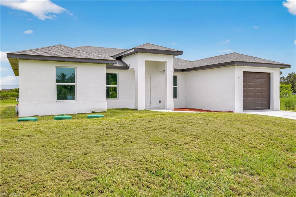 321 Ranier Avenue Lehigh Acres, FL 33974 - Photo 3 of 40 a front view of house with yard