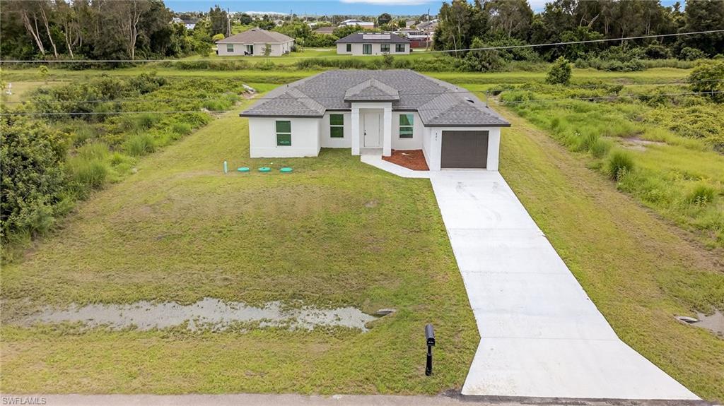 321 Ranier Avenue Lehigh Acres, FL 33974 - Photo 31 of 40 a front view of a house with a yard