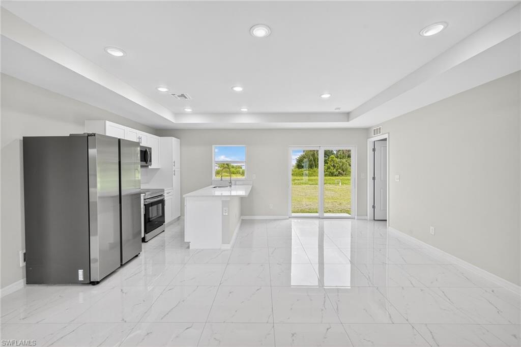 321 Ranier Avenue Lehigh Acres, FL 33974 - Photo 5 of 40 a view of a kitchen with a sink and a refrigerator