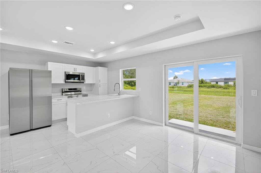 321 Ranier Avenue Lehigh Acres, FL 33974 - Photo 7 of 40 a view of kitchen with microwave and refrigerator