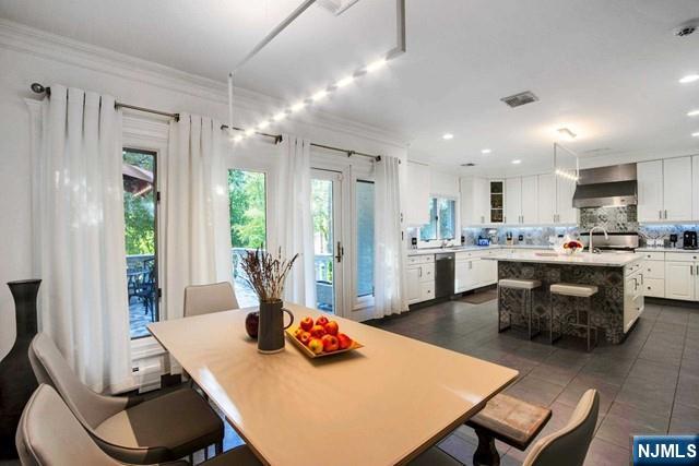 99 Ogle Road Old Tappan, NJ 07675 - Photo 23 of 50 a kitchen with stainless steel appliances wooden floor dining table and chairs