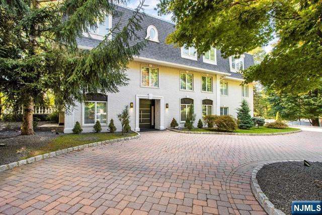 99 Ogle Road Old Tappan, NJ 07675 - Photo 3 of 50 a view of a white house with a yard and large trees