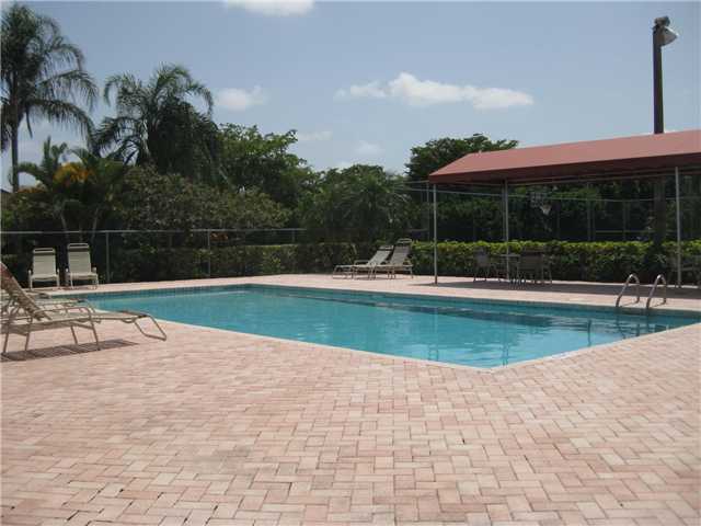8548 Eagle Run Drive Boca Raton, FL 33434 - Photo 28 of 30 a view of swimming pool with lawn chairs and palm trees