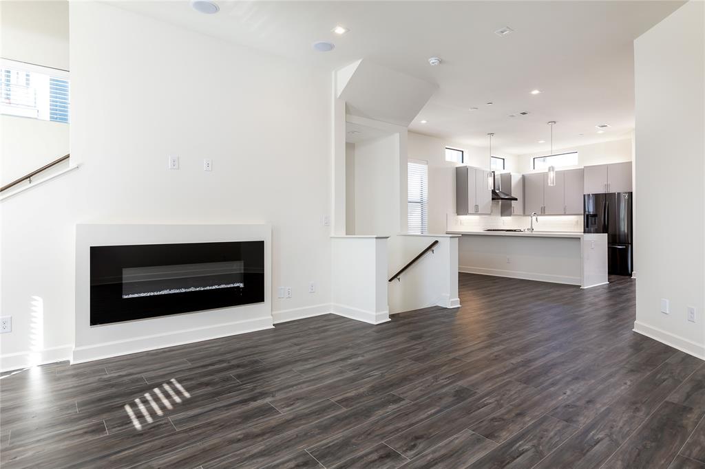 a view of kitchen living room with wooden floor and fireplace